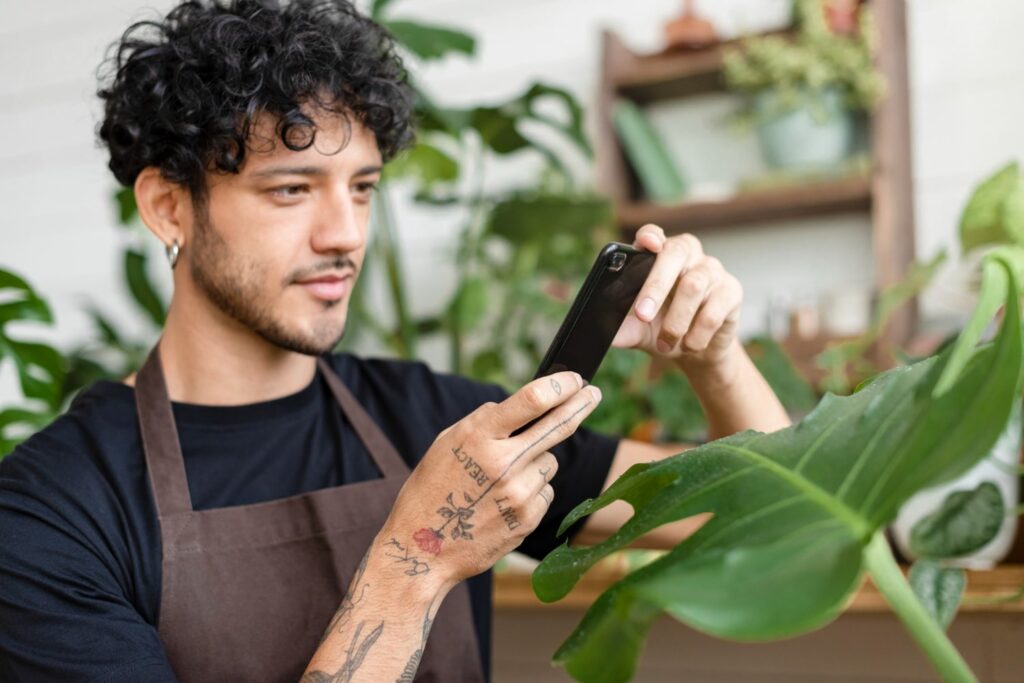 man takes photo houseplant share social media with a marketing package for small business